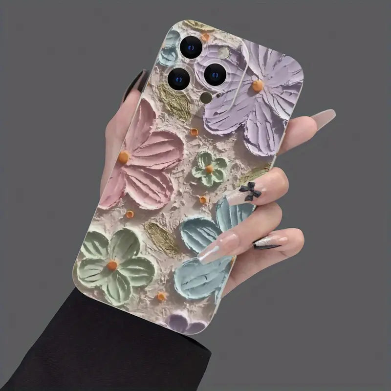 Hand holding a matte iPhone case with an artistic pastel floral print designed to look like raised textured flowers in pink, green, purple, and blue.