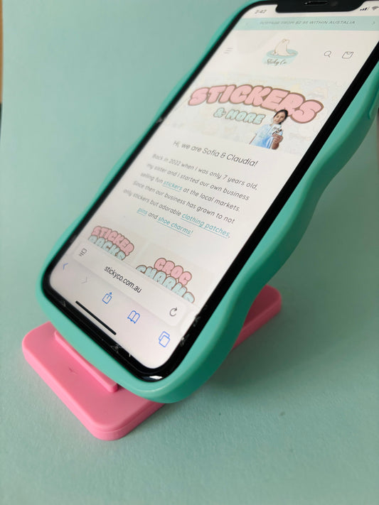 Phone resting in pink silicone character stand