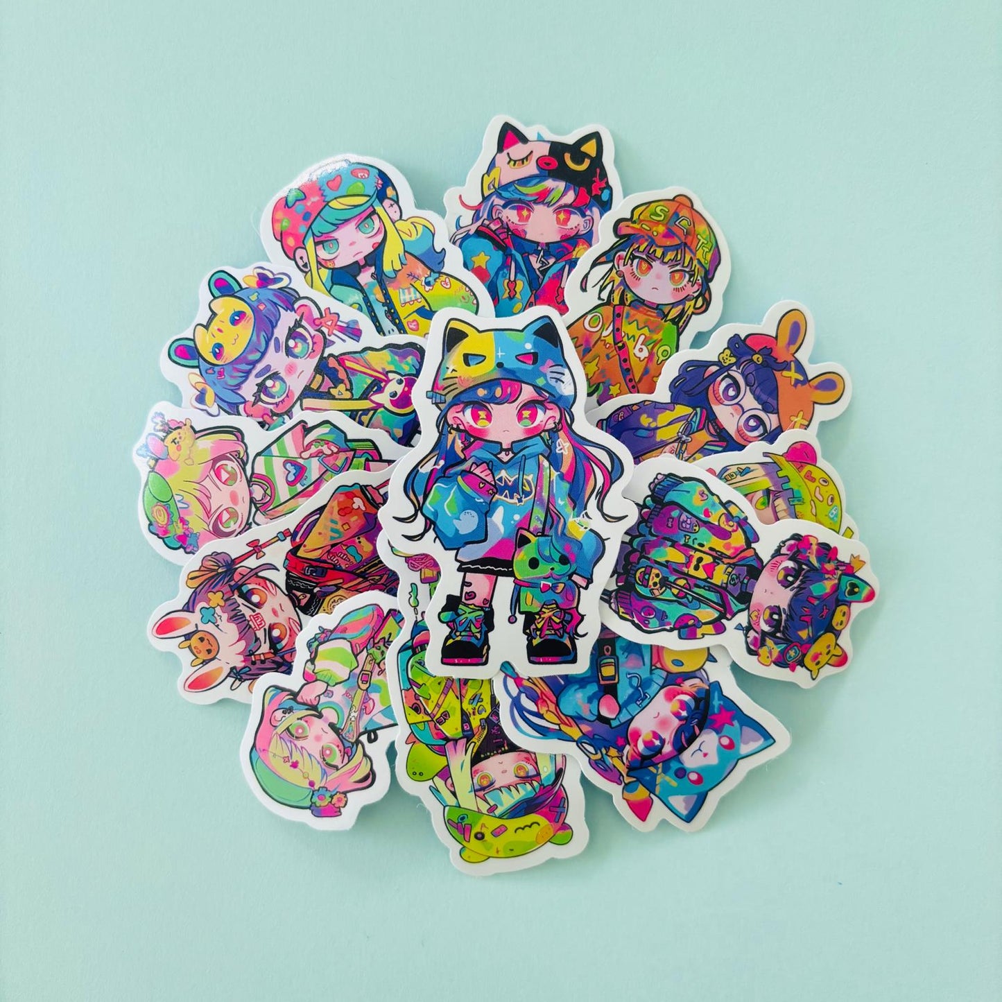 Bundle of 20 colourful anime-style mini stickers featuring chibi characters in vibrant Japanese streetwear outfits, arranged in a circle